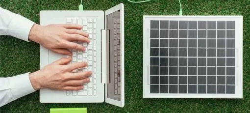Ein Laptop wird über Solarzellen mit Strom versorgt